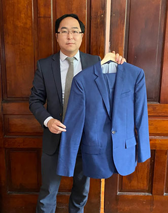 Andy Kim holding the blue suit he was wearing when he helped clean up the Capitol on January 6, 2021